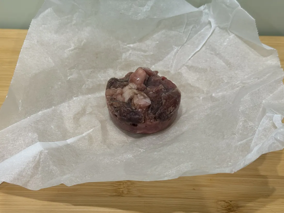 A Cats That Raw frozen puck unwrapped from parchment paper